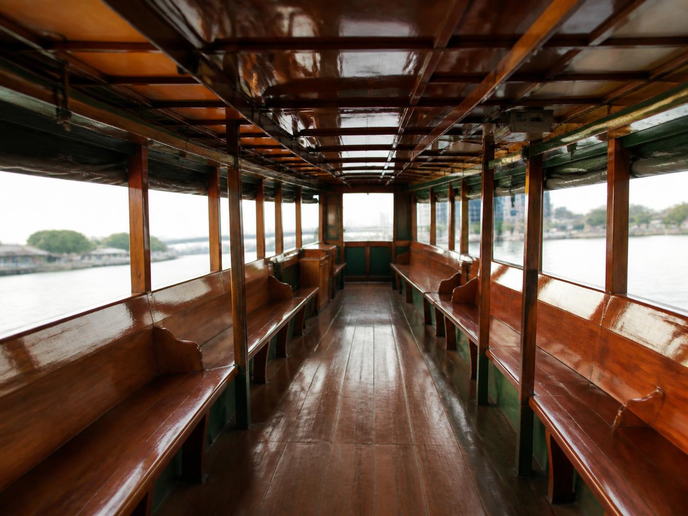 ภายในเรือไม้สักโดยสาร พร้อมที่นั่งยาวสองฝั่งสำหรับผู้ร่วมพิธี